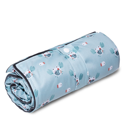 A compact fold up waterproof diaper changing station with a blue crab pattern, rolled up with a snap closure to show its non-bulky travel design.