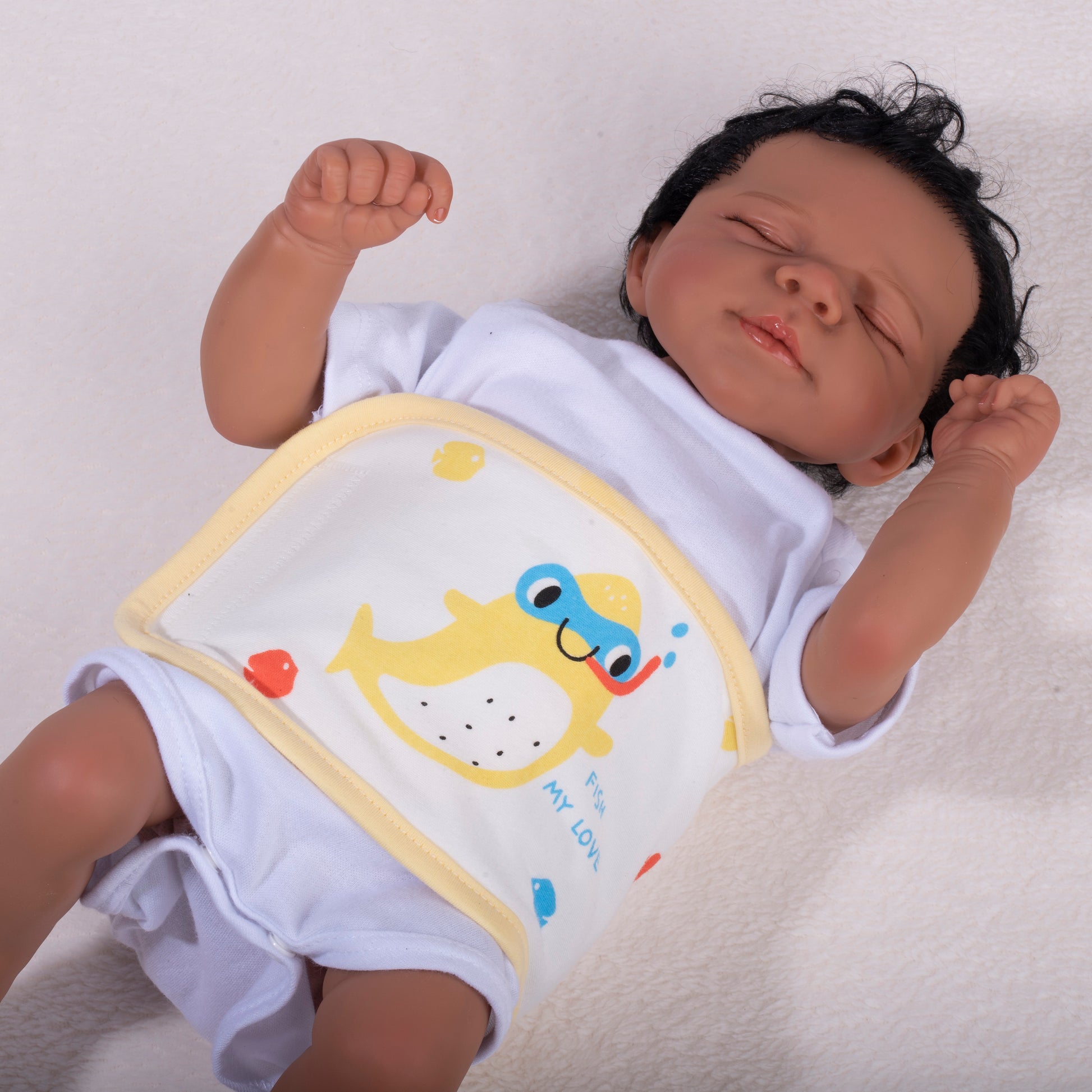 A newborn baby dummy wearing a pale yellow soft cotton baby waist warmer to demonstrate the infant umbilical cord colic band placement.