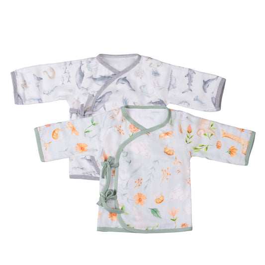 A pair of organic bamboo muslin newborn kimono style monk style tops, one with a gray ocean creature pattern and the other with a green plant and rabbit pattern, laid flat.